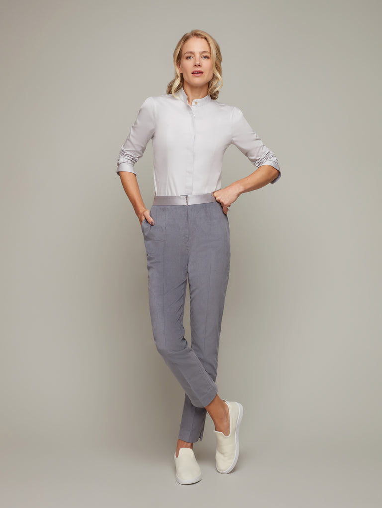Front view of PILASTER tapered suiting trousers in Frost grey with sneakers, available from British sustainable fashion brand DEPLOY 